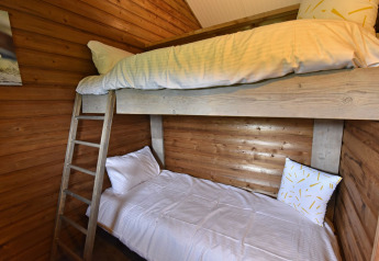 Accogliente stanza con letti a castello e pareti in legno nella cabina del Camping de Koeksebelt, Paesi Bassi.