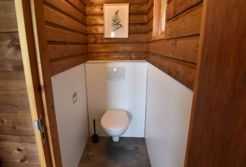 Foto einer modernen Toilettenkabine mit Holzwänden in einer Hütte im Camping de Koeksebelt, Niederlande.