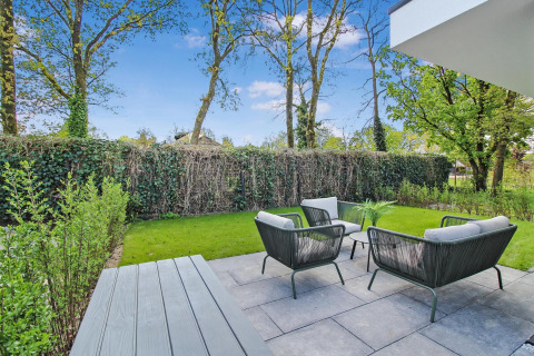 Terraza moderna en Forest villa con muebles de jardín, césped verde y entorno natural y tranquilo.
