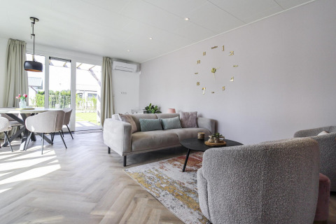 Salón moderno en Eco Lodge de Uniq Leisure, Países Bajos, con decoración cálida y vistas al jardín.