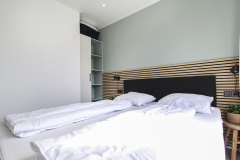 Dormitorio moderno en Eco Lodge de Uniq Leisure en los Países Bajos, con cama doble y decoración simple.