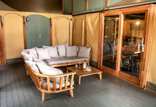Zona de descanso exterior en Kings Lodge + Hot Tub de Sandberghe, Países Bajos, con muebles de madera.