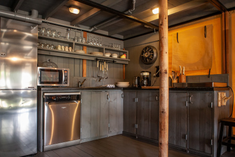 Área de cocina en la tienda safari Kings Lodge en Sandberghe, Países Bajos, con electrodomésticos modernos.