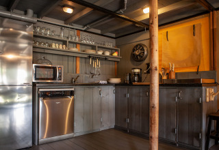Área de cocina en la tienda safari Kings Lodge en Sandberghe, Países Bajos, con electrodomésticos modernos.