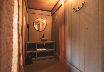 Badeværelse i safari telt på Kings Lodge + Hot Tub, Sandberghe, Holland, med trævægge og vask.