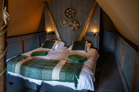 Interieur van de Kings Lodge safari tent met twee eenpersoonsbedden en knusse inrichting bij Sandberghe.