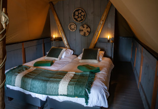 Interior de la tienda safari Kings Lodge con dos camas individuales y decoración acogedora en Sandberghe.
