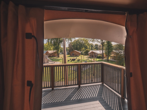 Vista desde el balcón del safari tent Kings Lodge con jacuzzi en Sandberghe, Países Bajos, estilo glamping.