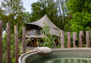 Tienda safari Kings Lodge con jacuzzi en Sandberghe, Países Bajos, rodeada de bosque y naturaleza.