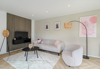 Moderne stue med minimalistisk indretning og kunst på væggene, taget på Eco Lodge.