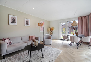 Sala de estar moderna en Eco Lodge con muebles en tonos pastel, grandes ventanales y decoración elegante.