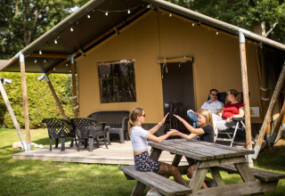 Familie genießt entspannte Zeit vor einem Safarizelt bei De Scherpenhof, Niederlande; Kinder spielen.