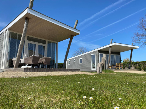 Dos casas diminutas modernas Beach Loft con terrazas y muebles de exterior en Camping Zonneweelde, Países Bajos.
