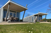 Dos casas diminutas modernas Beach Loft con terrazas y muebles de exterior en Camping Zonneweelde, Países Bajos.