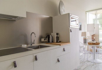 Moderne lille køkken i Beach Loft på Camping Zonneweelde i Holland med mikroovn og kaffemaskine.