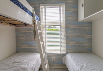 Stanza con letto a castello e letti singoli al Beach Loft, Camping Zonneweelde, Paesi Bassi, luce naturale.