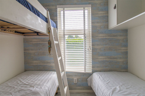 Kamer met stapelbed en enkele bedden in Beach Loft, Camping Zonneweelde, Nederland, daglicht.