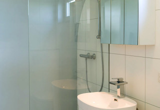 Petite salle de bain moderne avec douche, lavabo autoportant et armoire miroir au Beach Loft, Camping Zonneweelde.