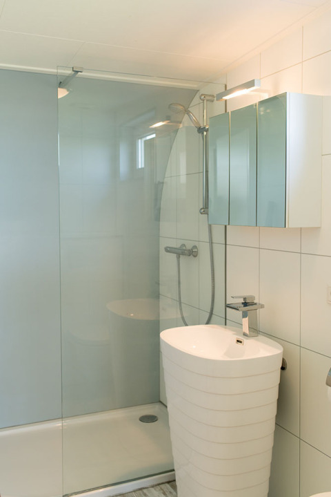 Moderne lille badeværelse med bruseniche, fritstående håndvask og spejlskab i Beach Loft, Camping Zonneweelde.