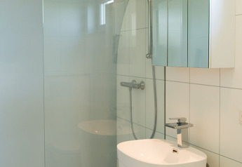 Bagno moderno e piccolo con doccia, lavabo freestanding e armadietto a specchio al Beach Loft, Camping Zonneweelde.