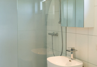 Moderne lille badeværelse med bruseniche, fritstående håndvask og spejlskab i Beach Loft, Camping Zonneweelde.