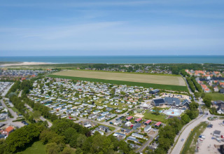 Luftfoto af Camping Zonneweelde med tiny houses og Beach Loft, nær havet i Nederlandene en solrig dag.