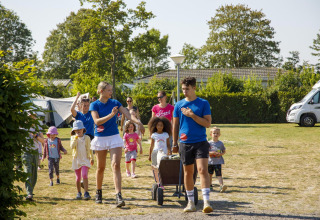 Niños y adultos disfrutan de actividades al aire libre en Beach Loft, Camping Zonneweelde, Países Bajos.