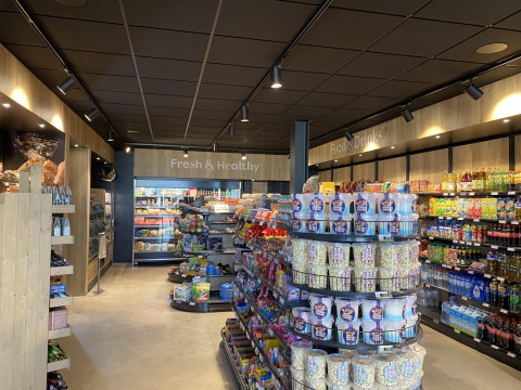 Tienda moderna con aperitivos, bebidas y productos frescos en una zona de alojamiento glamping.