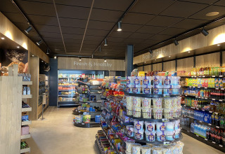 Tienda moderna con aperitivos, bebidas y productos frescos en una zona de alojamiento glamping.