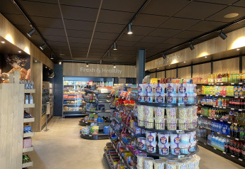 Tienda moderna con aperitivos, bebidas y productos frescos en una zona de alojamiento glamping.