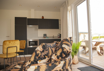 Modernes Wohn- und Küchenbereich in der Dune Lodge de Luxe auf Camping Zonneweelde mit Terrasse.