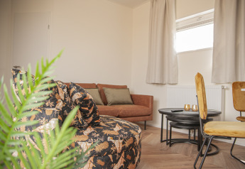 Lichte, moderne zithoek van Dune Lodge de Luxe op Camping Zonneweelde in Nederland, met stijlvolle inrichting.