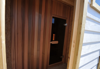 Indgang til en træbeklædt sauna ved Beach Loft + Wellness, Camping Zonneweelde, Holland, set udefra.