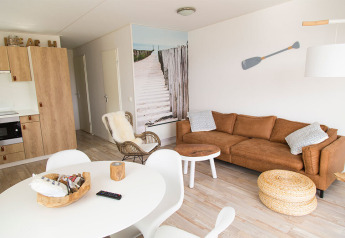 Luminoso soggiorno a tema spiaggia al Beach Loft presso Camping Zonneweelde, Olanda, con arredi moderni.