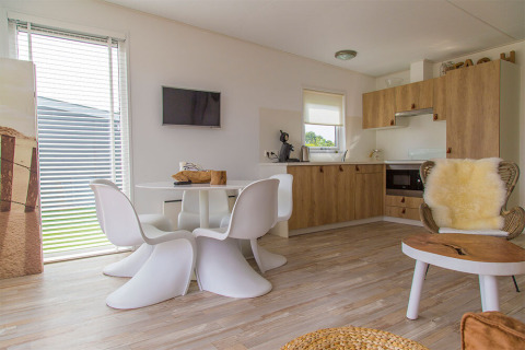 Interno moderno del Beach Loft al Camping Zonneweelde, con cucina luminosa e zona pranzo nei Paesi Bassi.