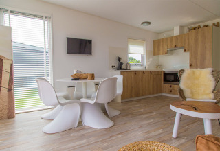Moderne indretning af Beach Loft på Camping Zonneweelde, med lyst køkken og spiseområde i Holland.