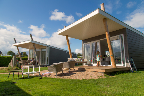 Cabanes modernes Beach Loft au Camping Zonneweelde aux Pays-Bas avec terrasse, mobilier et beau temps.
