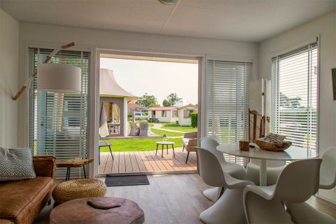 Intérieur moderne du Beach Loft au Camping Zonneweelde aux Pays-Bas avec vue sur la terrasse et le jardin.
