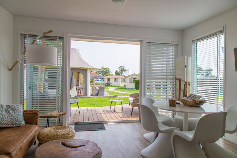 Interni moderni del Beach Loft al Camping Zonneweelde nei Paesi Bassi con vista sul patio e sul giardino.