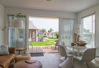 Interni moderni del Beach Loft al Camping Zonneweelde nei Paesi Bassi con vista sul patio e sul giardino.