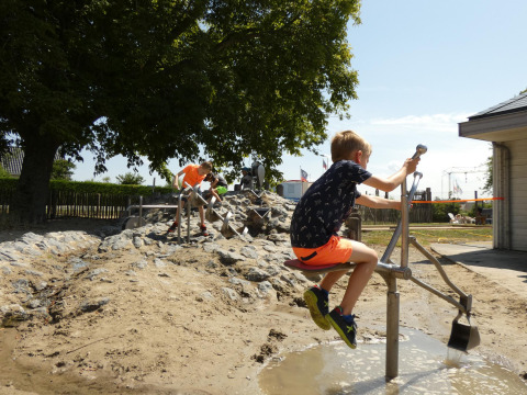 Bambini che giocano con acqua e sabbia al Beach Loft di Camping Zonneweelde nei Paesi Bassi.