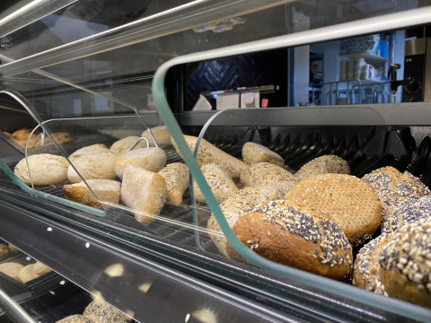 Brød og boller vises i en glasmonter på Beach Loft ved Camping Zonneweelde i Holland.
