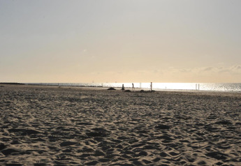 Strandbillede taget ved Beach Loft på Camping Zonneweelde, Holland, med strand og solnedgang.