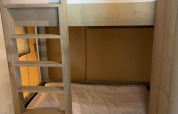 Stockbetten mit Holzleiter in einem Zimmer der Glampingtent Family - Gent bei Urban-Gardens, Belgien.