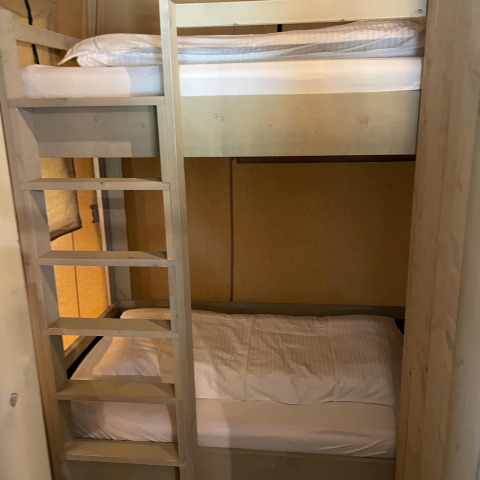 Stockbetten mit Holzleiter in einem Zimmer der Glampingtent Family - Gent bei Urban-Gardens, Belgien.