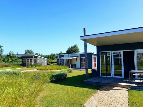 Casas pequeñas modernas en Comfort Lodge, Kompas Camping Nieuwpoort en Bélgica, rodeadas de jardines verdes.