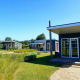 Casas pequeñas modernas en Comfort Lodge, Kompas Camping Nieuwpoort en Bélgica, rodeadas de jardines verdes.