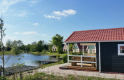 Cabaña grupal junto al lago en Holiday park Eigen Wijze, Países Bajos, con porche y otras casas.