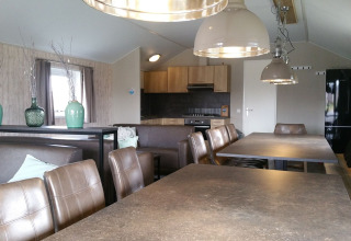 Interieur van een groepslodge op Vakantiepark Eigen Wijze in Nederland met moderne eet- en keukenfaciliteiten.