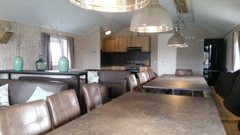 Interior de un lodge grupal en Holiday park Eigen Wijze en los Países Bajos, con comedor y cocina modernos.